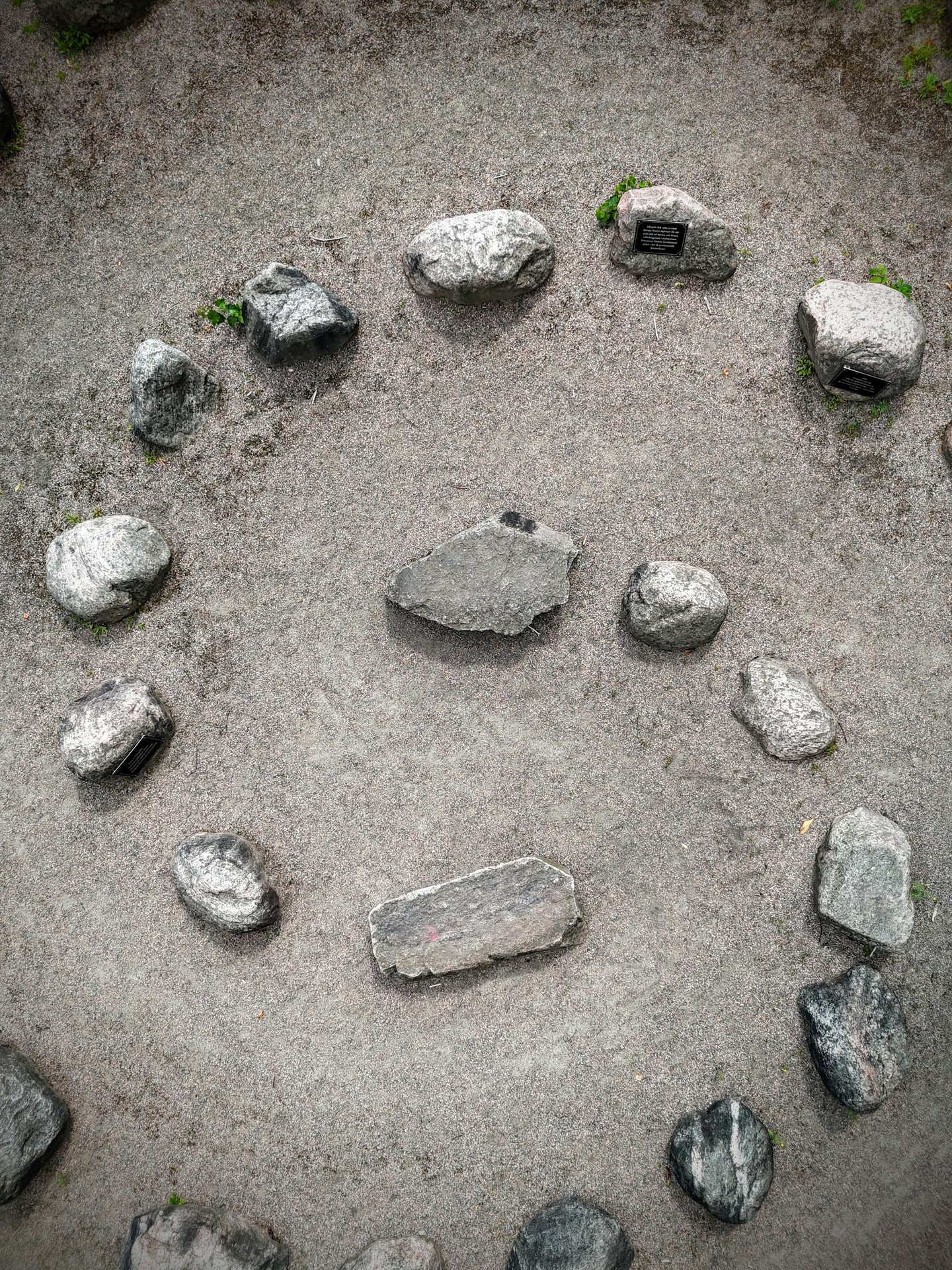 A small circle of stones seen from above on pale gravel.
